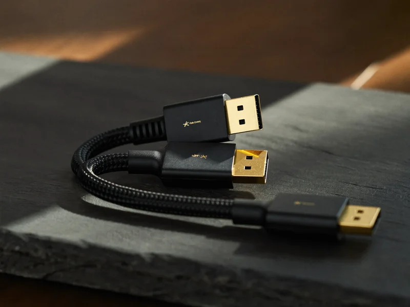 Cablu HDMI cu conectori metalici, așezat într-o curbă lină pe fundal închis